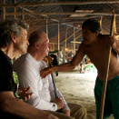 Kong Harald og Regnskogfondets Dag Hareide lytter til medisinmannen Lorival som forteller om yanomamienes historie og leveset (Foto: Rainforest Foundation Norway / ISA Brazil)